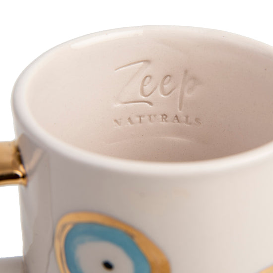 Zeep Naturals | White Ceramic Evil Eye Coffee/Tea Cups | Catskills-inspired artisan natural soaps, luxurious Turkish towels, bathrobes, throws, and bedding. Discover handmade coffee cups, milk dispensers, and olive wood kitchen utensils—crafted with care for your home