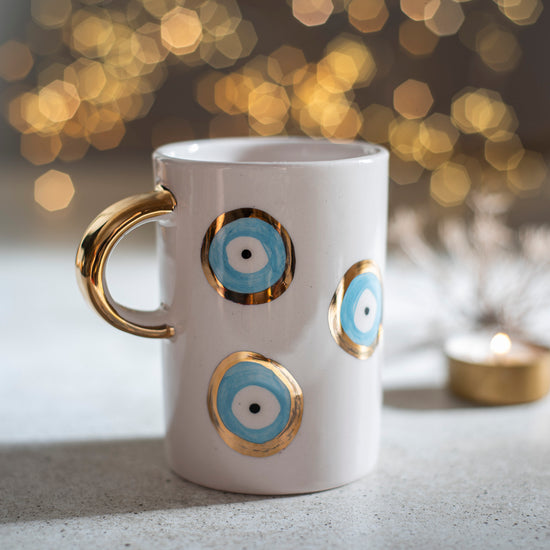 Zeep Naturals | White Ceramic Evil Eye Coffee/Tea Cups | Catskills-inspired artisan natural soaps, luxurious Turkish towels, bathrobes, throws, and bedding. Discover handmade coffee cups, milk dispensers, and olive wood kitchen utensils—crafted with care for your home