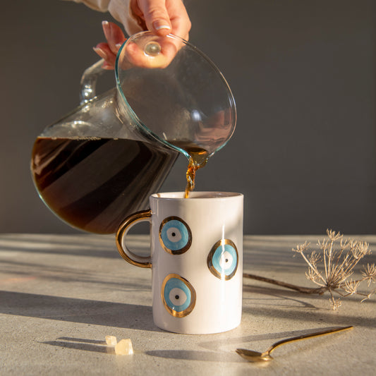 Zeep Naturals | White Ceramic Evil Eye Coffee/Tea Cups | Catskills-inspired artisan natural soaps, luxurious Turkish towels, bathrobes, throws, and bedding. Discover handmade coffee cups, milk dispensers, and olive wood kitchen utensils—crafted with care for your home